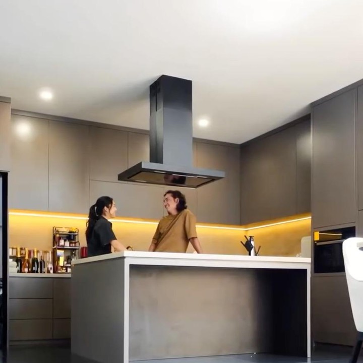 <p>Area dapur tampil modern dan fungsional dengan kabinet atas dan bawah berwarna abu-abu gelap. Pencahayaan LED berwarna kuning di sepanjang rak turut mempercantik ruangan sekaligus menciptakan suasana yang nyaman.&nbsp;(Foto: Instagram @cantitachril)</p>
