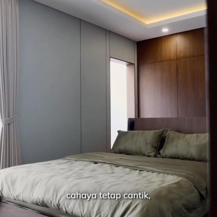 <p>Kamar utama juga didominasi warna abu-abu yang memberikan kesan tenang dan elegan. Untuk melengkapi desainnya, pasangan ini memilih gorden <em>blackout</em> dengan tingkat kegelapan 100 persen. Selain menjaga privasi, gorden tersebut membantu menghalangi panas matahari agar suhu ruangan tetap nyaman. &ldquo;Selain karena <em>privacy</em>, <em>blackout</em> juga menahan panas matahari. Hasilnya kamar terasa lebih sejuk, cahaya tetap cantik, dan suasananya seperti hotel,&rdquo; tutur Canti.&nbsp;(Foto: Instagram @cantitachril)</p>