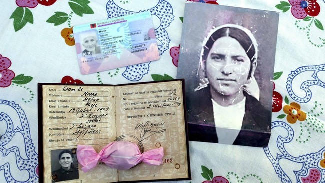 This photograph taken in the village of Ferras, near Kucove, some 80 kilometres from the capital Tirana on October 3, 2026 shows official documents indicating the date of birth of 117-year-old Qamile Marra and an old photograph of her at the age of 1