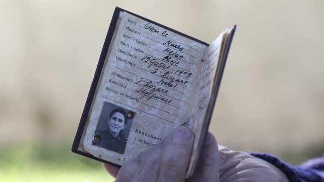 The 117-year-old Qamile Marra shows an identity document from Albania's communist era during an interview with AFP in the garden of her home in the village of Ferras, near Kucove, some 80 kilometres from the capital Tirana on October 3, 2026. At 117,