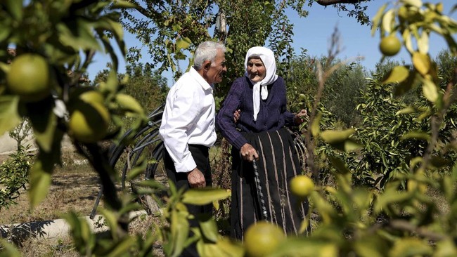 The 117-year-old Qamile Marra speaks with her son Hysen Marra, 80, in the garden of her home in the village of Ferras, near Kucove, some 80 kilometres from the Albanian capital Tirana on October 3, 2026. At 117, Qamile Marra's priority isn't proving