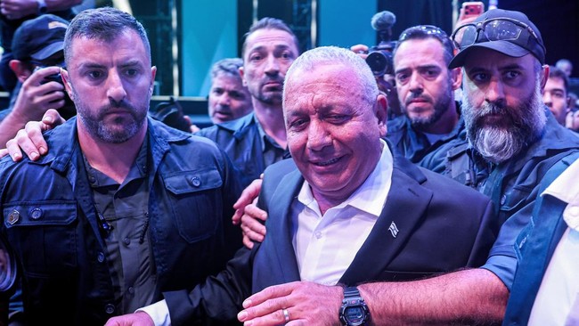 Security guards surround Gadi Eisenkot, Israel's former military chief of staff and leader of the Yashar party, as he arrives for the party's final campaign rally before the legislative election, in Tel Aviv on October 25, 2026. Israel heads to the p