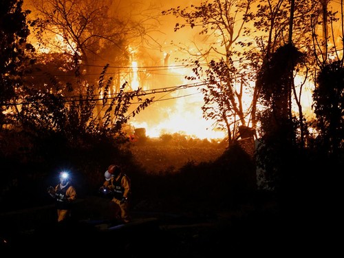 Firefighters walk in front of the scene of the fire as a fire broke out in Guryong village in Seoul, South Korea, October 27, 2026. REUTERS/Kim Soo-hyeon