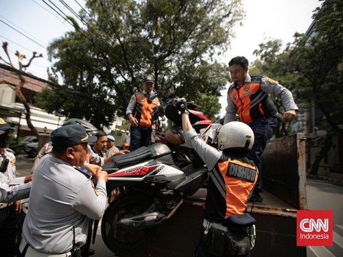 Petugas Suku Dinas Perhubungan Jakarta Selatan mengangkut sepeda motor yang parkir sembarangan ke atas truk di Jalan Adityawarman, Jakarta Selatan, Kamis (29/10/2026). Penindakan tersebut dilakukan untuk menertibkan parkir liar yang mengganggu fungsi