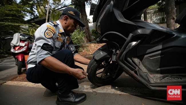 Petugas Suku Dinas Perhubungan Jakarta Selatan mengangkut sepeda motor yang parkir sembarangan ke atas truk di Jalan Adityawarman, Jakarta Selatan, Kamis (29/10/2026). Penindakan tersebut dilakukan untuk menertibkan parkir liar yang mengganggu fungsi