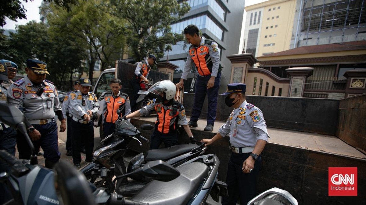 Petugas Suku Dinas Perhubungan Jakarta Selatan mengangkut sepeda motor yang parkir sembarangan ke atas truk di Jalan Adityawarman, Jakarta Selatan, Kamis (29/10/2026). Penindakan tersebut dilakukan untuk menertibkan parkir liar yang mengganggu fungsi