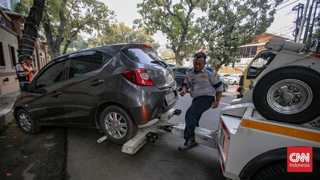 Petugas Suku Dinas Perhubungan Jakarta Selatan mengangkut sepeda motor yang parkir sembarangan ke atas truk di Jalan Adityawarman, Jakarta Selatan, Kamis (29/10/2026). Penindakan tersebut dilakukan untuk menertibkan parkir liar yang mengganggu fungsi