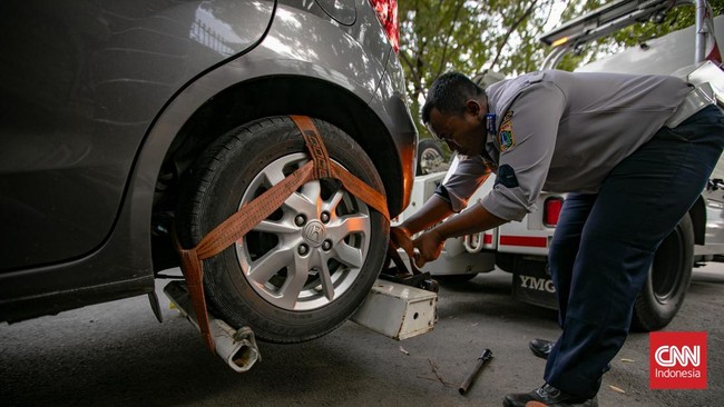 Petugas Suku Dinas Perhubungan Jakarta Selatan mengangkut sepeda motor yang parkir sembarangan ke atas truk di Jalan Adityawarman, Jakarta Selatan, Kamis (29/10/2026). Penindakan tersebut dilakukan untuk menertibkan parkir liar yang mengganggu fungsi