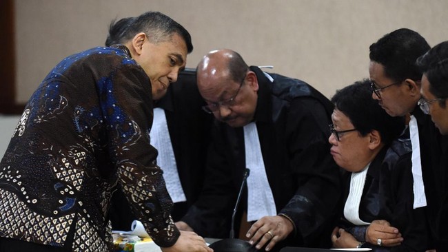 Terdakwa kasus dugaan pemerasan dan gratifikasi pengurusan izin tinggal WNA di lingkungan Ditjen Imigrasi, Silmy Karim (kiri) berbincang dengan kuasa hukumnya saat mengikuti sidang pembacaan surat dakwaan di Pengadilan Tipikor, Jakarta, Kamis (29/10/