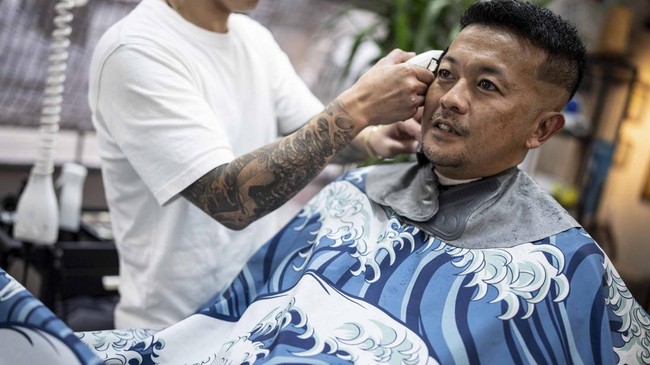 This photo taken on August 27, 2026 shows Tekisasu, an active yakuza gangster allied to a major clan, having his hair cut at a barbershop in Tokyo. Japan's yakuza operate an organised crime empire worth billions of dollars and have long dominated the
