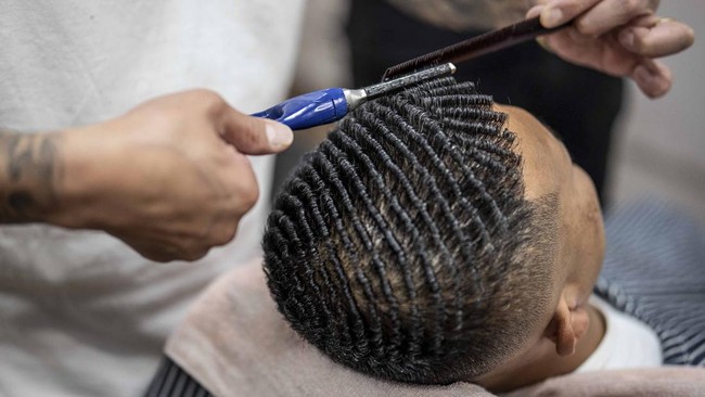 This photo taken on August 27, 2026 shows Tekisasu, an active yakuza gangster allied to a major clan, having his hair permed at a barbershop in Tokyo. Japan's yakuza operate an organised crime empire worth billions of dollars and have long dominated