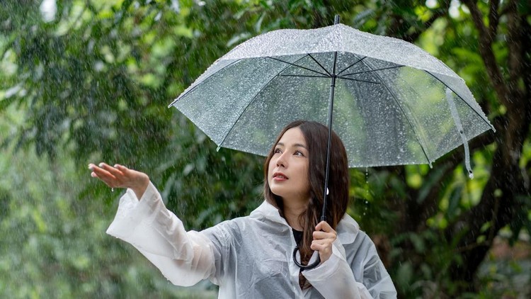 Asian beautiful woman holding umbrella in raining season at the park&period; Lifesyle Concept&period;